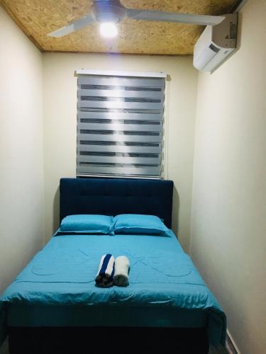 1 dormitorio con 1 cama con sombrero y ventana en The Pines House @ PCB (home stay), en Kota Bharu