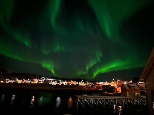 Un'aurora nel cielo sopra una città di Bugøynes a Bugøynes