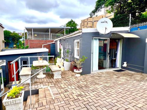 a blue building with a patio with potted plants at Terebinte Bed & Breakfast in Durban