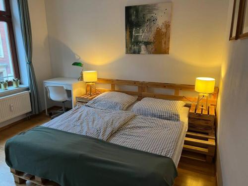een slaapkamer met een bed en een bureau met 2 lampen bij BELIEBT: Zentrales & ruhiges Innenstadtapartment in Halle an der Saale