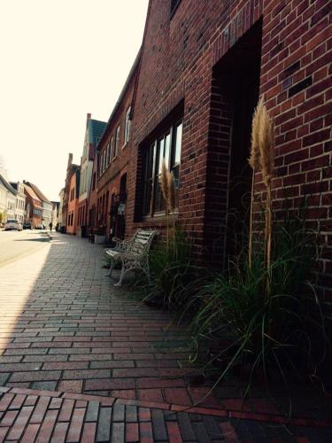 a brick building with a bench on a brick street at Lüttje Ferienhuus in Tönning