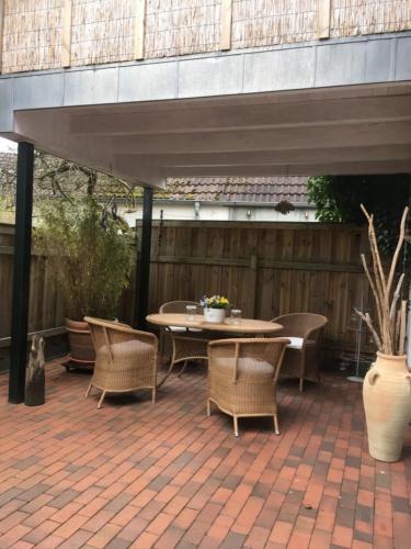 a patio with a table and chairs on a brick patio at Lüttje Ferienhuus in Tönning