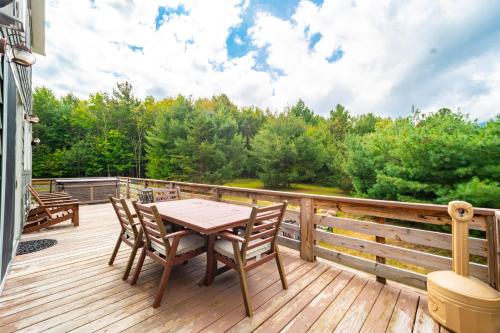 a wooden deck with a table and chairs on it at Whiteface Mountain Chalet in Wilmington
