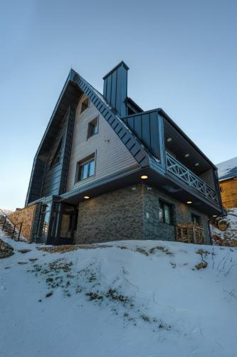 a house with a deck in the snow at Casa Valley Paradiso - Jahorina in Jahorina