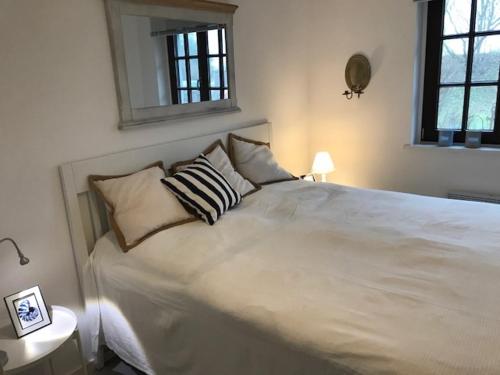 um quarto com uma grande cama branca e 2 almofadas em Nordseewölkchen 3 em Katingsiel