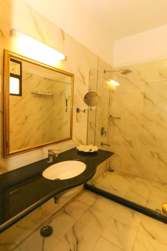 ein Badezimmer mit Waschbecken, Spiegel und Dusche in der Unterkunft Hotel Boheda Palace Udaipur in Udaipur