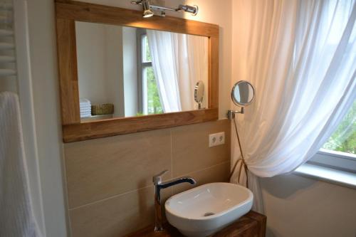ein Bad mit einem Waschbecken und einem Spiegel in der Unterkunft Carlotta Haupthaus in Osterhever