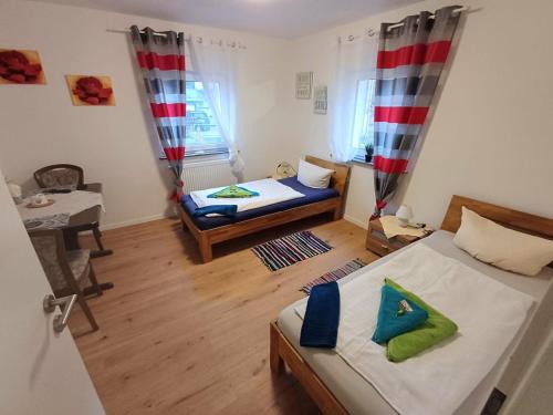 Habitación pequeña con 2 camas y mesa. en APARTMENTS / WOHNUNG IN HAIBACH, en Haibach