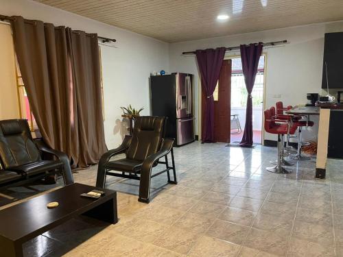 een woonkamer met stoelen en een tafel bij Villa Ingracia" Rustig omgeving waar je wakker wordt van de mooie vogelgeluiden" in Paramaribo