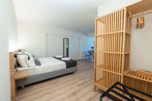 a bedroom with a bed and a wooden book shelf at Athens Airport Living spaces in Spáta