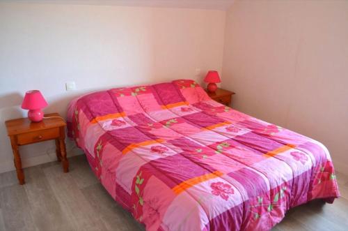 um quarto com uma cama rosa e 2 candeeiros nas mesas em Gîte 5 avec piscine - plage 3kms em Clohars-Carnoët
