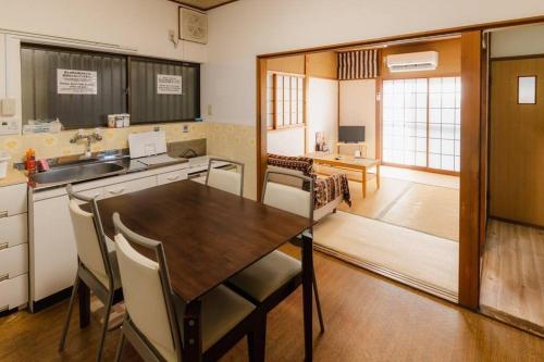 a kitchen with a table and chairs in a room at HAT京終、京終駅徒歩４分。奈良公園・奈良町へ行くのにおすすめ！ in Mitsugarasuchō