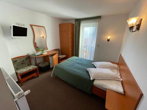 - une chambre d'hôtel avec un lit et un miroir dans l'établissement Pensiunea Olt Centrum/ Olt Centrum panzió, à Băile Tuşnad
