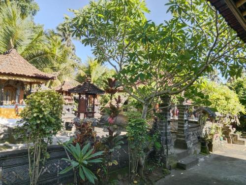 a garden in a resort with trees and a building at Wikan House in Bebandem