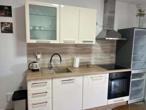 a kitchen with white cabinets and a sink and a stove at Apartment Seman in Vela Luka