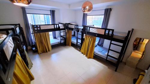 Cette chambre comprend 3 lits superposés et 2 fenêtres. dans l'établissement The White Stay, à Dubaï