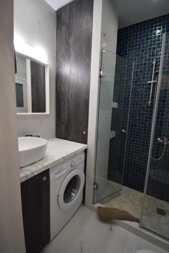 a bathroom with a shower sink and a washing machine at Piraeus Blue in Piraeus