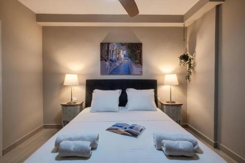 um quarto com uma grande cama branca e 2 almofadas em Varkiza Beach House em Vári