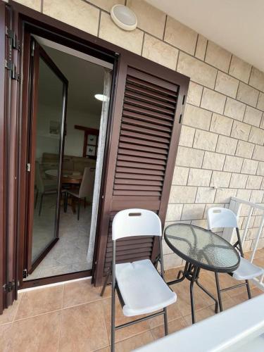 a patio with two chairs and a table and a table at Apartment Seman in Vela Luka