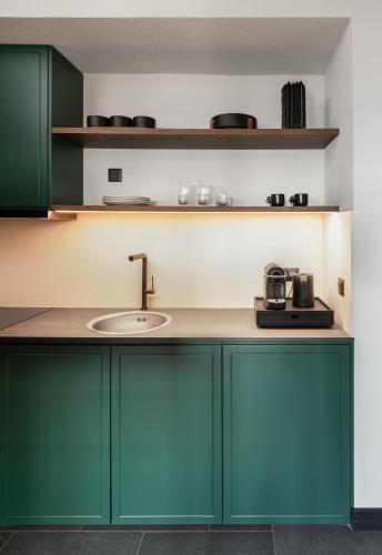 a kitchen with green cabinets and a sink at Unedo All Seasons Boutique Hotel in Palaios Panteleimon