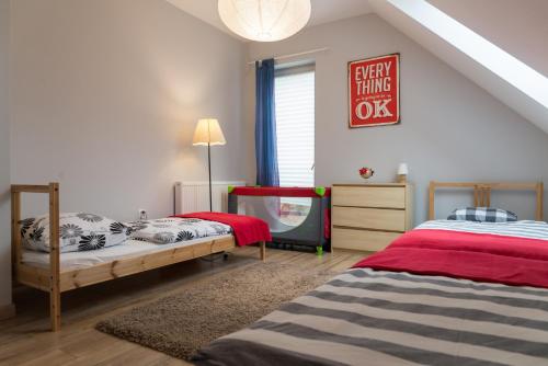 a bedroom with two beds and a tv in it at VacationClub - Nadrzeczna VacationHome 1 in Ustroń