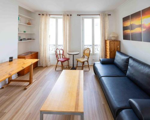 ein Wohnzimmer mit einem Sofa und einem Tisch in der Unterkunft Well located apartment in Paris in Paris