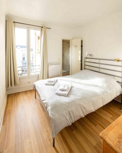 une chambre avec un grand lit avec deux serviettes dessus dans l'établissement Well located apartment in Paris, à Paris