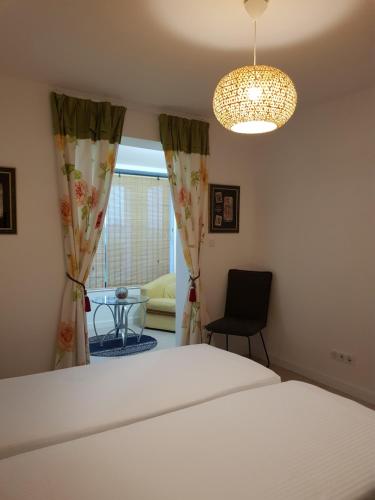 a bedroom with a bed and a chair and a window at Calme et Nature in Rouen