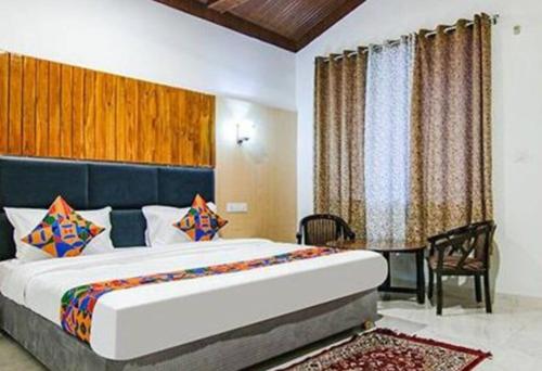a bedroom with a large bed and a table at Corbett Jungle Breeze Resort in Rāmnagar