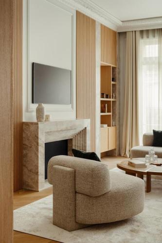 - un salon avec une chaise et une cheminée dans l'établissement Appartement Luxe et Rénové - Champs-Élysées, à Paris