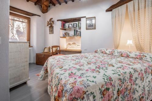 a bedroom with a bed with a floral bedspread at A casa da nonna Elisa in Castel del Piano