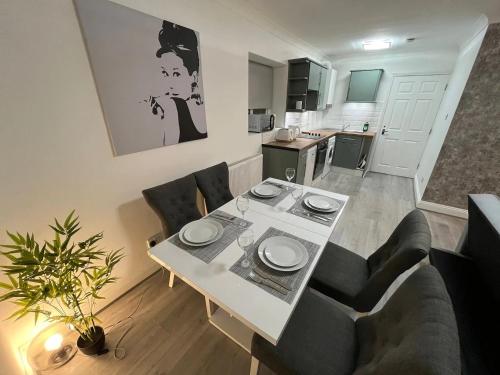 a living room with a table and chairs and a kitchen at Contemporary Style in the Heart of London in London