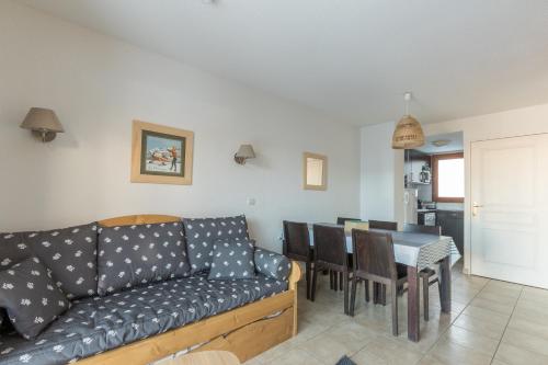 un salon avec un canapé et une table dans l'établissement Chalet Orée des pistes - Piscine et sauna, aux Orres