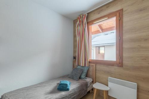 une petite chambre avec un lit et une fenêtre dans l'établissement Chalet Orée des pistes - Piscine et sauna, aux Orres