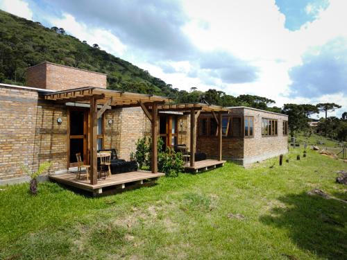a brick house with a porch and a patio at Monte Sião Château in Urubici
