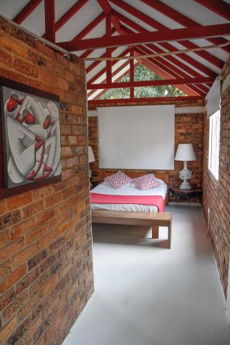 a room with two beds in a brick wall at Hacienda Siete Sentidos in La Mesa
