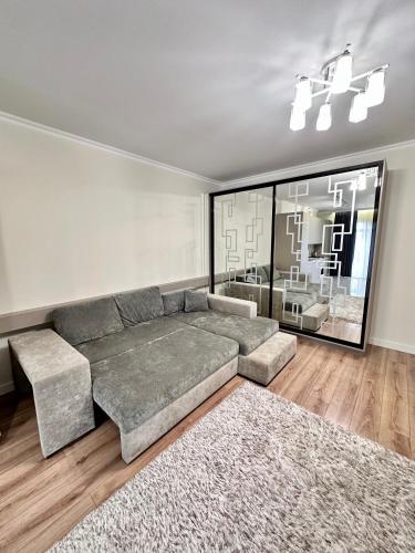 a living room with a couch and a large window at Luxury Apartments-Belochka in Uzhhorod