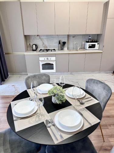 a dining room table with plates and wine glasses at Luxury Apartments-Belochka in Uzhhorod