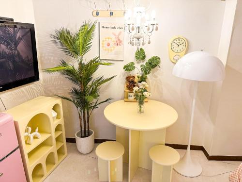 a room with a table and stools and a table with flowers at 8 Hotel in Seoul