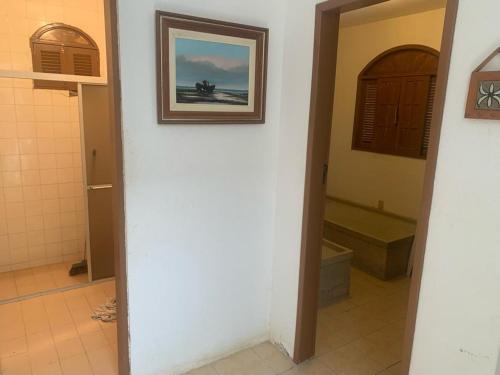 a bathroom with a toilet and a picture on the wall at Casa Beira Mar - Enseada dos Golfinhos in Itamaracá