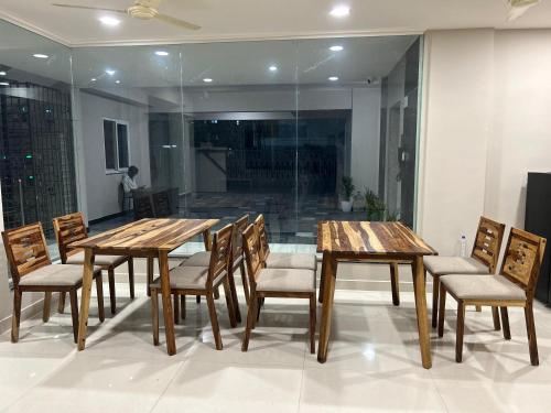 a dining room with wooden tables and chairs at Nectar Living - Iris in Hyderabad