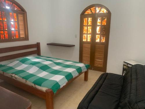 uma sala de estar com uma cama e uma janela em Casa Beira Mar - Enseada dos Golfinhos em Itamaracá