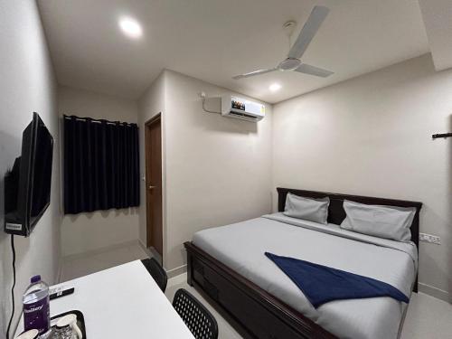 a small room with a bed and a television at Nectar Living - Iris in Hyderabad