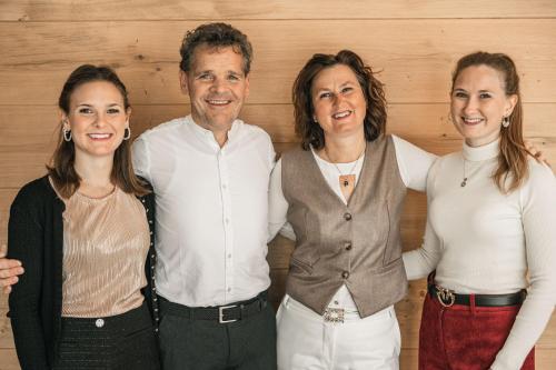 a group of three people posing for a picture at Garni Hotel Miara - Your Dolomites Home in Selva di Val Gardena