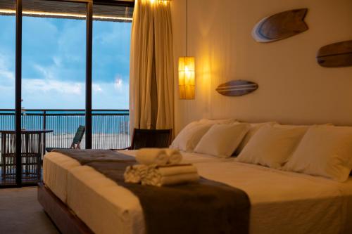 a bedroom with a large bed with a view of the ocean at Nanii Hotel in São Miguel do Gostoso