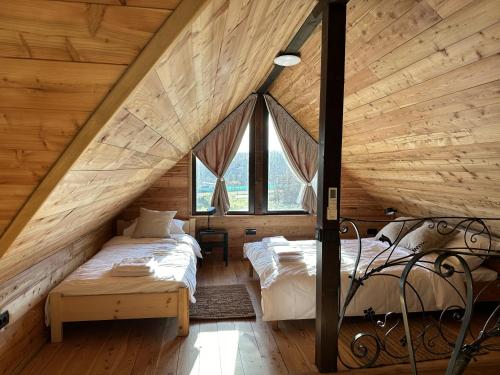 2 camas en un dormitorio ático con paredes de madera en Ozoni & Sauna, en Sopot