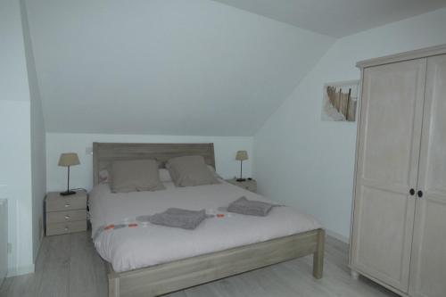 a bedroom with a bed and a dresser at Les Galets bleus in Le Crotoy