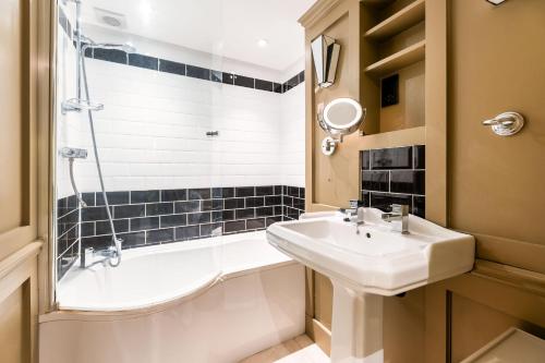 a bathroom with a sink and a tub and a shower at Luxury One Bedroom Mezzanine in Paddington in London