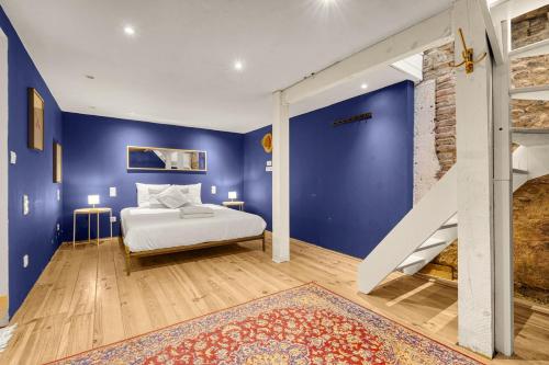 - une chambre avec un lit et un mur bleu dans l'établissement Le Cilaos - Superbe appt en centre ville, à Toulouse