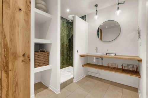 La salle de bains est pourvue d'un lavabo et d'une douche avec un miroir. dans l'établissement Le Cilaos - Superbe appt en centre ville, à Toulouse